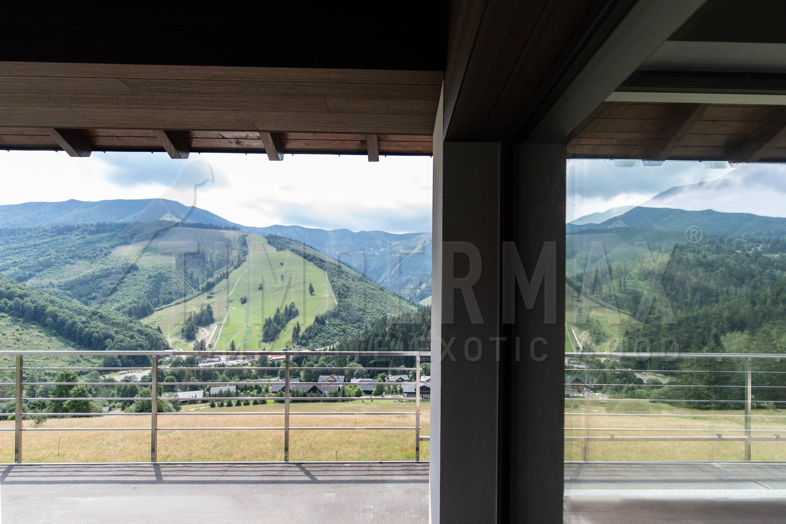 moderní balkon s fasádním obkladem imitace dřeva a výhledem na hory