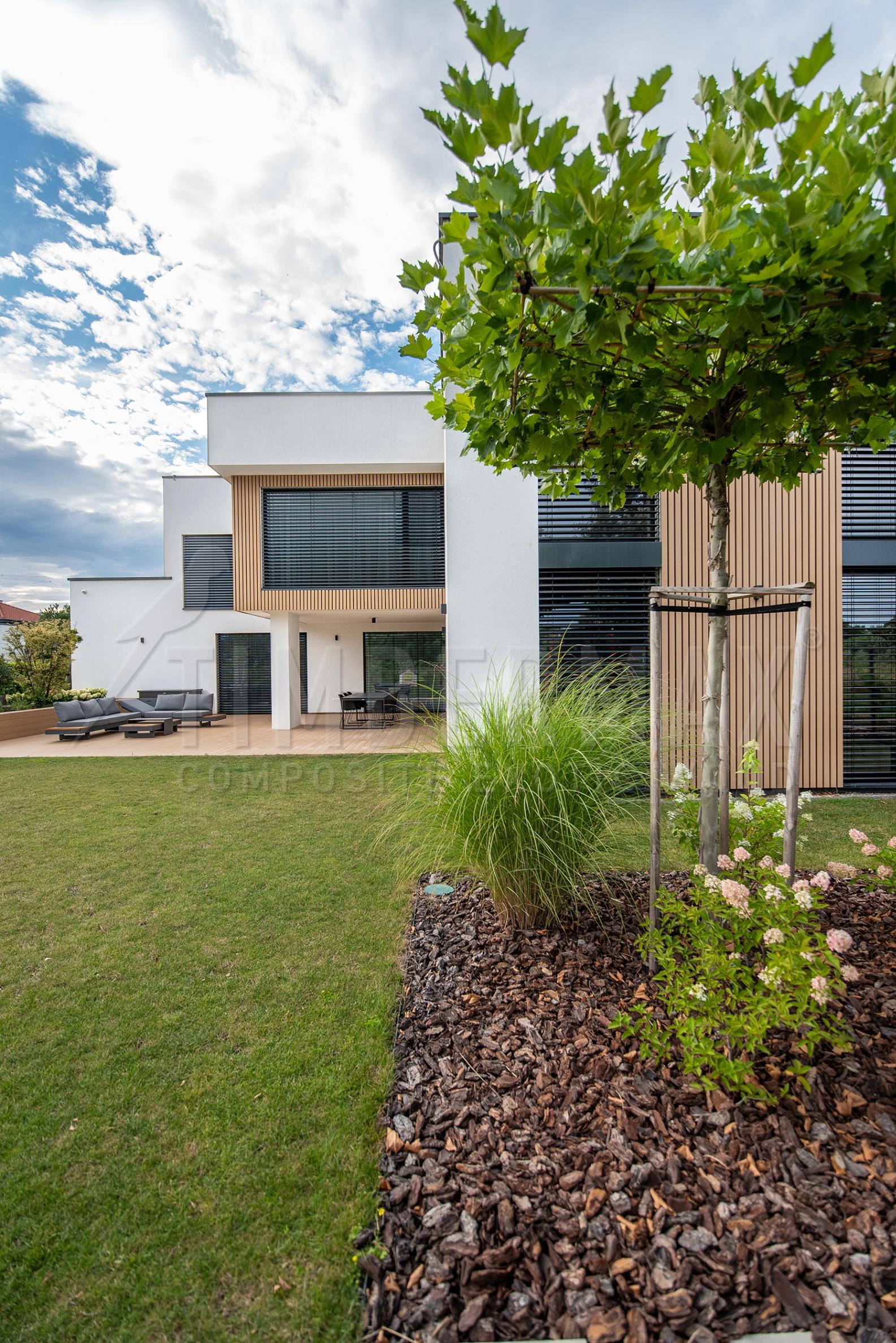 garden of a modern house with a composite terrace and slatted facade