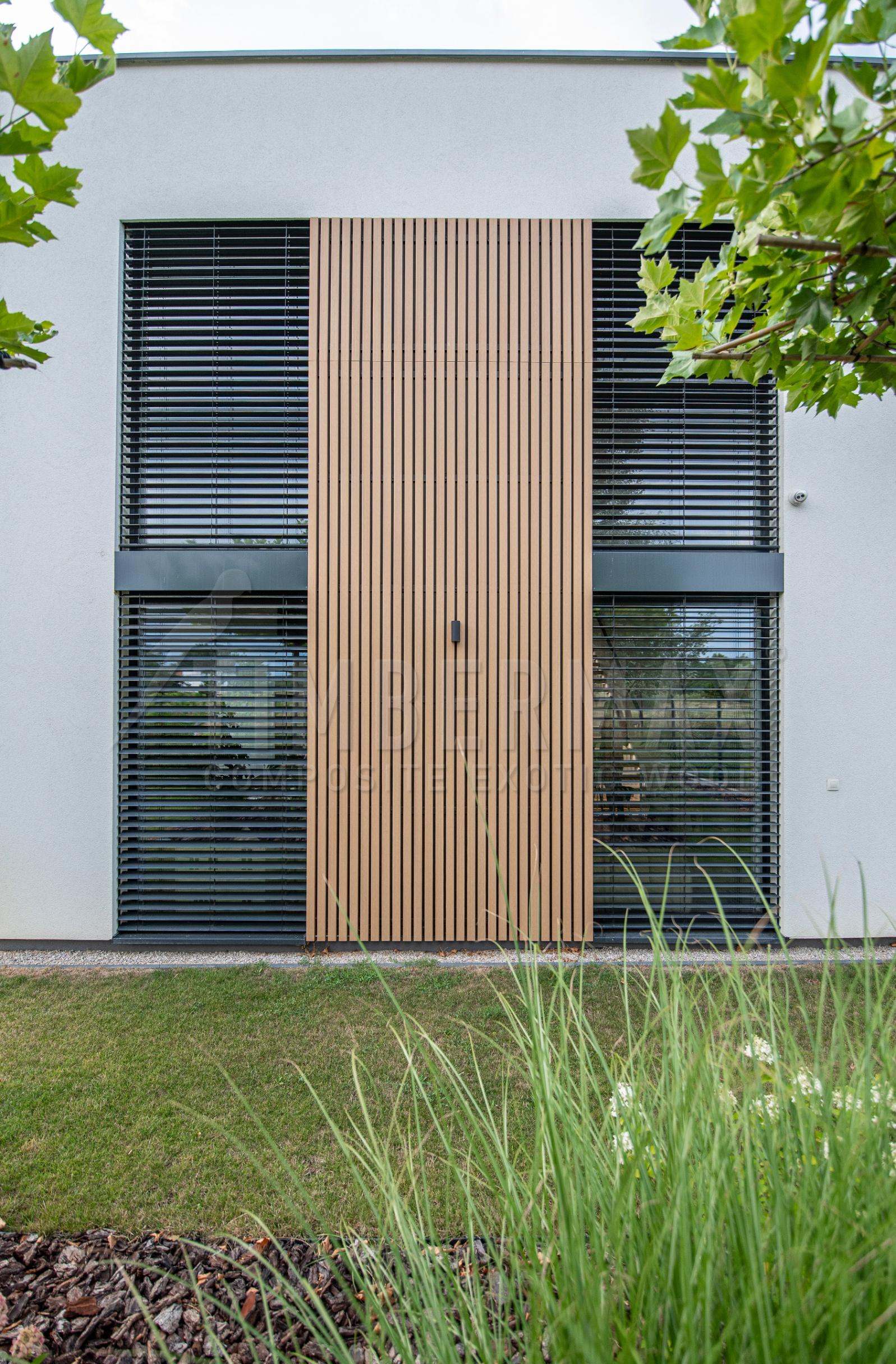 detail of the vertical sunshades made of composite boards on the facade of the house