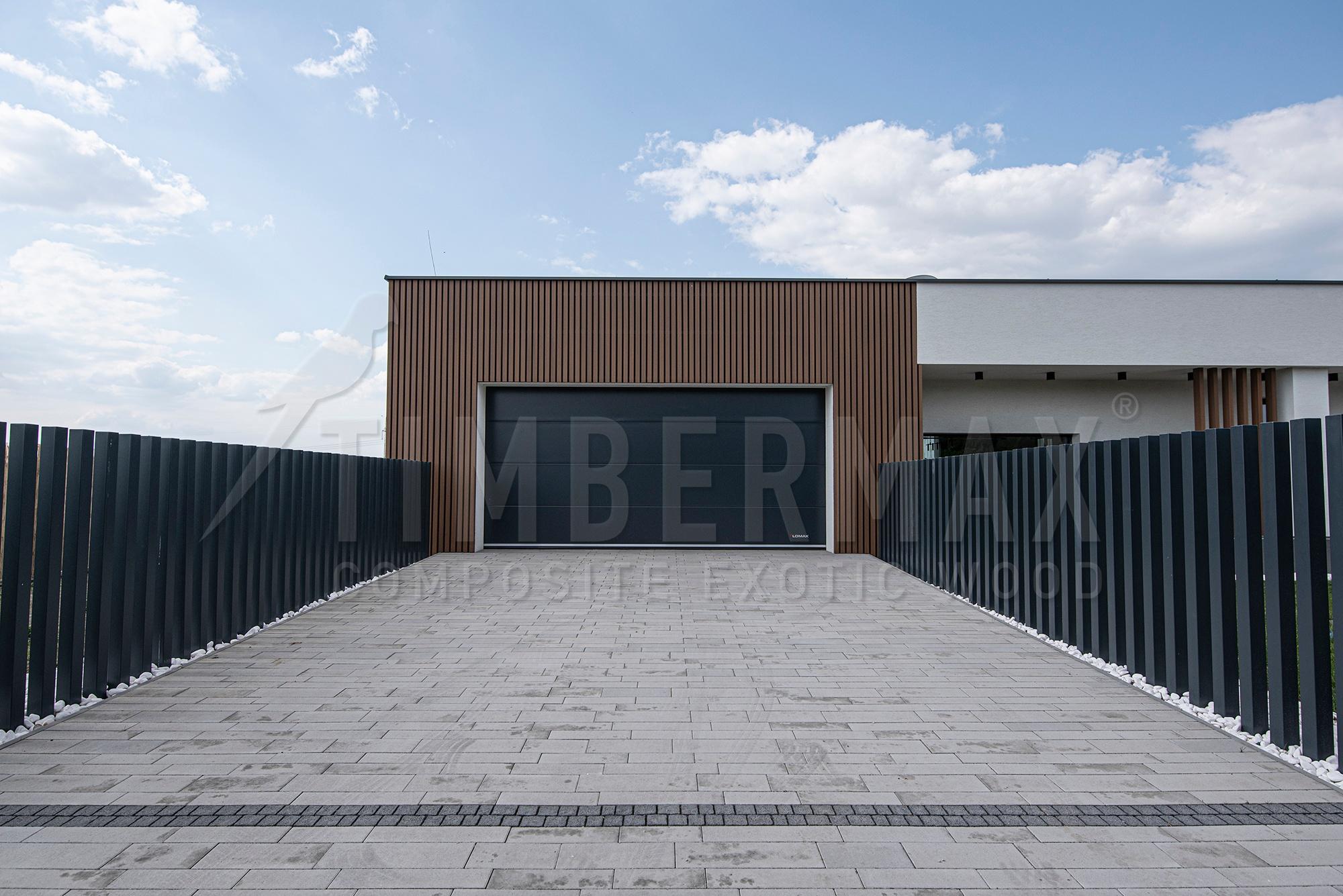 driveway to the garage with a slatted facade of the house