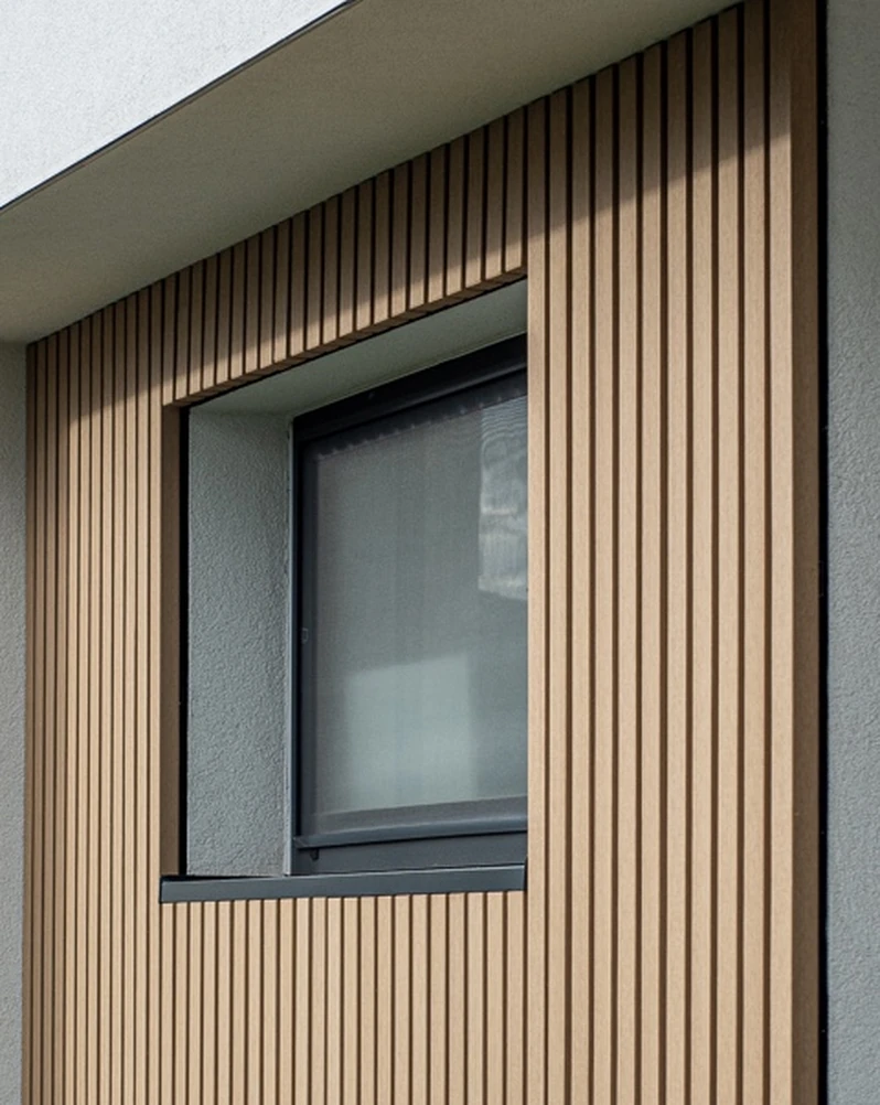 Vertikale Timbermax P60 Fassadenlamellen an einem dunklen Fenster, Referenzprojekt Jazdecká.
